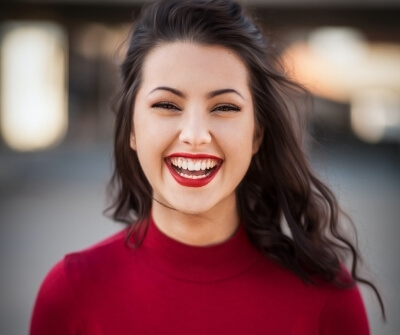 vrouw bruin lang haar rode lippen lachen