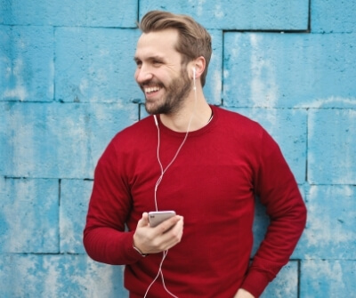 man blij haar baard koptelefoon lachen rode trui